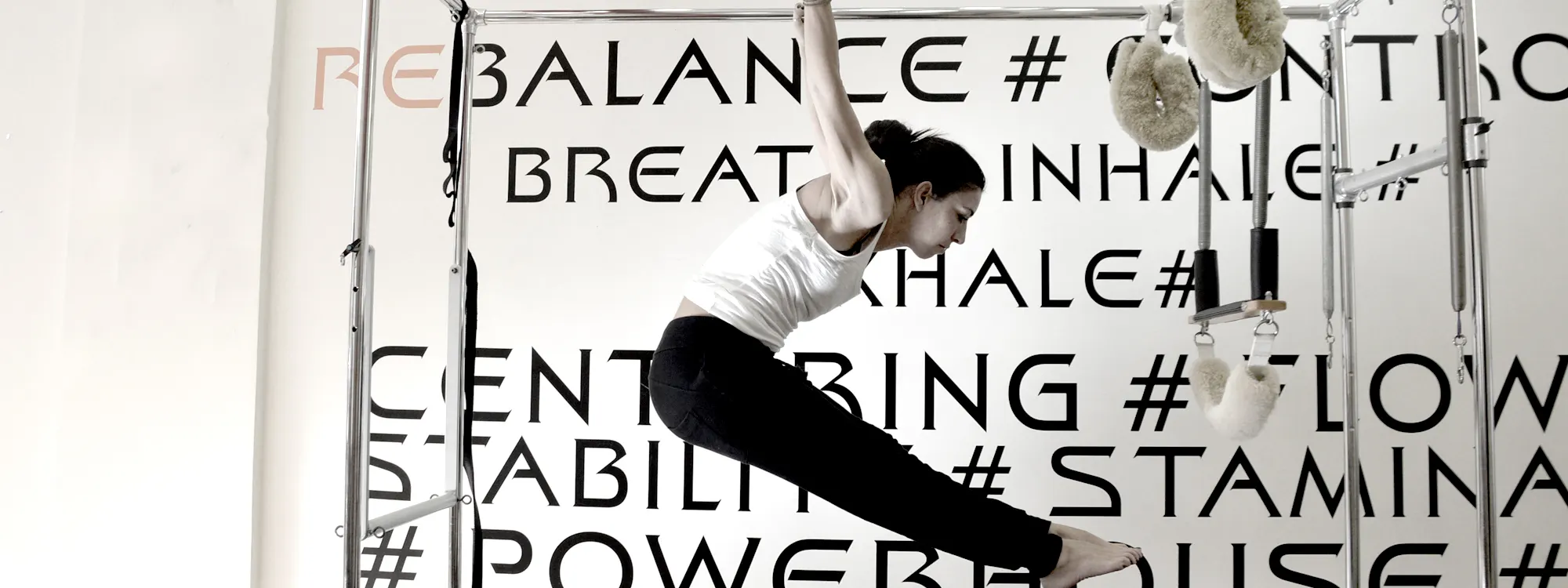 An exercise on the cadillac in front of the studio wall