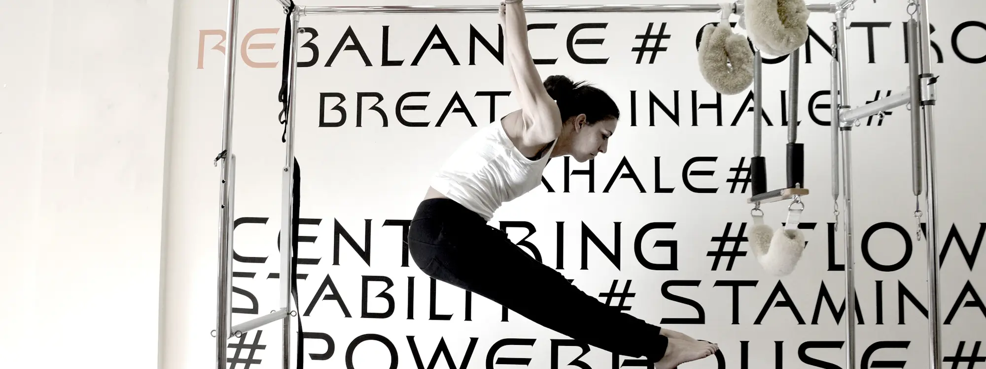 An exercise on the cadillac in front of the studio wall