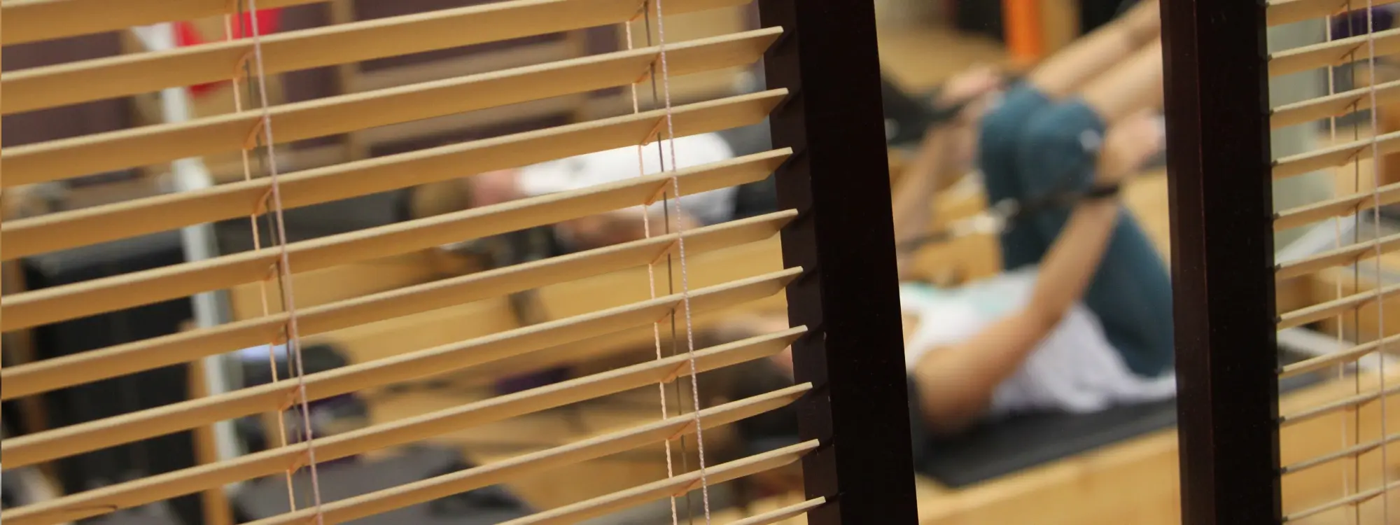 Working out on a reformer behind the wooden screens